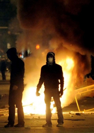 Anarchističtí mladíci u hořící barikády v Aténách.