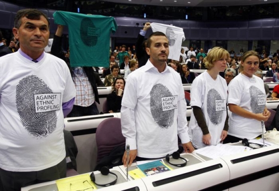 Delegáti unijní konference o Romech s protestním nápisem na tričku.