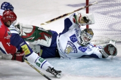 Finský brankář Mika Noronen se snaží odrazit ruský útok Antona Buta (vlevo) během zápasu na Švédských hokejových hrách.