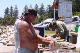 Rybáři při kuchání úlovku.