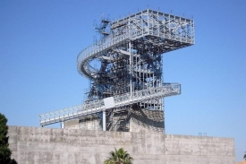 Nad stavbou se tyčí ocelová konstrukce věže.