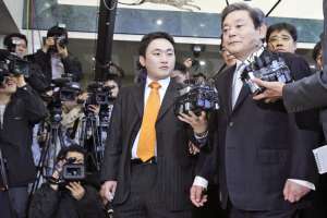 Šéf Samsungu I Kun-hi (vpravo) na cestě k vyšetřovateli.