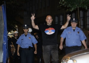 Policisté vedou posmutnělého srbského nacionalistu do antonu.