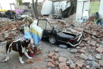 Žena u zničeného domu ve městě Talca.