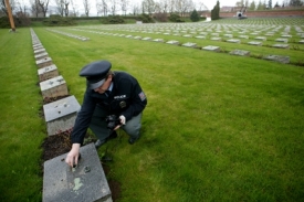 Poničené náhrobky na hřbitově prohlíželi policisté.