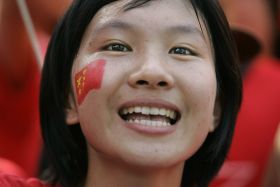 Jedna z členek početné čínské komunity v Thajsku vítá oheň z Olympie.