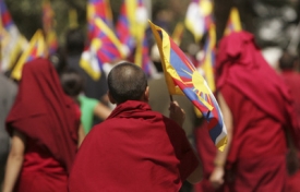 Tibetský mnich s vlajkou v ruce během demonstrací.