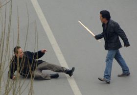 Tibeťan útočí klackem na Číňana ve Lhase, 14. 3. 2008.