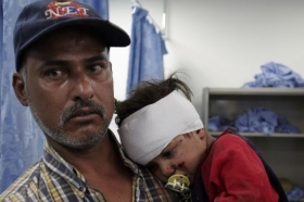 Iráčan nese své dítě, zraněné při bombovém útoku v Bagdádu.